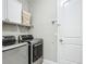 Well-equipped laundry room with modern washer and dryer, plus upper cabinets for storage at 591 Lake Smart Blvd, Winter Haven, FL 33881