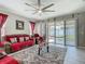 Comfortable living room with large ceiling fan, sliding glass doors to the outside, and floral patterned rug at 591 Lake Smart Blvd, Winter Haven, FL 33881