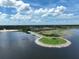 Aerial view of a lake with a scenic walkway leading to a park and lush landscape at 621 Rebecca Dr, St Cloud, FL 34769