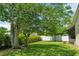 Spacious backyard featuring a manicured lawn, mature trees, and privacy fencing, perfect for relaxation and entertaining at 621 Rebecca Dr, St Cloud, FL 34769