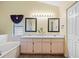 The bright bathroom offers double sinks, a large mirror, and ample cabinet space for storage at 621 Rebecca Dr, St Cloud, FL 34769