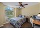 A bedroom features a large window with a view, a paisley bedspread, and a ceiling fan at 621 Rebecca Dr, St Cloud, FL 34769