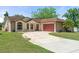 Charming single-story home featuring a well-manicured lawn and a red two-car garage at 621 Rebecca Dr, St Cloud, FL 34769