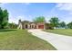 Charming home featuring a well-maintained lawn, mature trees, and a curved driveway leading to the front entrance at 621 Rebecca Dr, St Cloud, FL 34769
