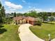 Inviting home featuring a lush lawn, mature trees, and a curved driveway leading to the welcoming front door at 621 Rebecca Dr, St Cloud, FL 34769