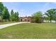 Charming home with a well-maintained lawn, mature trees, and a curved driveway leading to the front entrance at 621 Rebecca Dr, St Cloud, FL 34769