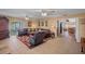A well lit living room features a brown leather sofa, tiled floors, and an outdoor living area at 621 Rebecca Dr, St Cloud, FL 34769
