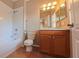 Functional bathroom with white tub/shower, wooden vanity, and tiled floor at 6957 Northwich Dr, Windermere, FL 34786