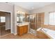Bright bathroom with tiled shower, soaking tub and wood vanity at 6957 Northwich Dr, Windermere, FL 34786
