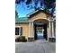 Charming clubhouse exterior with a green metal roof, stone accents, and a peek at the community pool at 6957 Northwich Dr, Windermere, FL 34786