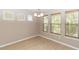 Bright dining room with laminate floors, three windows, and modern light fixture at 6957 Northwich Dr, Windermere, FL 34786