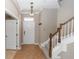 Bright foyer with tile flooring, staircase with wooden railing, and a coat rack, leading to the rest of the home at 6957 Northwich Dr, Windermere, FL 34786