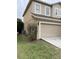 View of the exterior wall with the garage door and the AC on the grassy lot at 6957 Northwich Dr, Windermere, FL 34786