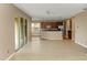 Open floorplan with laminate floors leading from living room to kitchen with stainless appliances and dark cabinets at 6957 Northwich Dr, Windermere, FL 34786