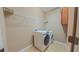 Well-lit laundry room featuring a modern washer, dryer, wire shelving, and tile flooring at 6957 Northwich Dr, Windermere, FL 34786