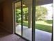 Patio view through glass doors that showcase the covered patio and lush green backyard at 6957 Northwich Dr, Windermere, FL 34786