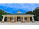 Community pool house with yellow siding, white columns, green shutters and roof perfect for summer fun at 6957 Northwich Dr, Windermere, FL 34786