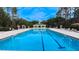 Large community swimming pool with ample seating and sun umbrellas, providing a refreshing oasis for residents at 6957 Northwich Dr, Windermere, FL 34786