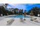 Community pool with multiple lounge chairs, umbrellas and a pergola, the perfect place to spend a summer day at 6957 Northwich Dr, Windermere, FL 34786