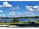 Scenic water view showcasing the lake surrounded by lush greenery and a clear blue sky with fluffy white clouds at 6957 Northwich Dr, Windermere, FL 34786
