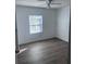 Cozy bedroom featuring gray wood-look floors, a window for natural light, and neutral walls at 710 Whispering Pines Dr, Auburndale, FL 33823