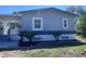 Charming single story home featuring a covered porch, complemented by fresh landscaping and healthy palm trees at 710 Whispering Pines Dr, Auburndale, FL 33823