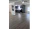 Spacious living room featuring gray wood-look floors flowing into a remodeled kitchen with gray cabinets at 710 Whispering Pines Dr, Auburndale, FL 33823