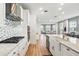 Bright white kitchen boasts stainless steel appliances, granite counters, designer backsplash, and an island sink at 7400 Estuary Lake Loop, Celebration, FL 34747