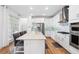 Modern kitchen featuring sleek white cabinetry, stainless steel appliances, and a spacious island with bar seating at 7400 Estuary Lake Loop, Celebration, FL 34747
