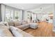 Open-concept living area with lots of natural light, hardwood floors, dining table, and a comfortable sectional couch at 7400 Estuary Lake Loop, Celebration, FL 34747