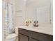 Well-lit bathroom with a single sink vanity, floral shower curtain, and clean white tile at 8042 Glenlloyd Ave, Winter Garden, FL 34787