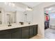 Elegant bathroom with double vanity sinks, a large mirror, and entry to an organized walk-in closet at 8042 Glenlloyd Ave, Winter Garden, FL 34787