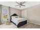 Cozy bedroom featuring a comfortable bed, ceiling fan, and natural light from the window at 8042 Glenlloyd Ave, Winter Garden, FL 34787