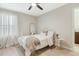 Stylish bedroom features a ceiling fan, a white iron bed frame, and neutral decor for a serene atmosphere at 8042 Glenlloyd Ave, Winter Garden, FL 34787
