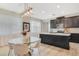Stylish dining area with modern light fixture and glass table with seating for four, next to a kitchen at 8042 Glenlloyd Ave, Winter Garden, FL 34787