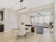 Inviting dining area with a glass table, modern lighting, seamlessly connected to the living room at 8042 Glenlloyd Ave, Winter Garden, FL 34787