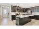 Modern kitchen featuring dark cabinets, stainless steel appliances, and a center island with a quartz countertop at 8042 Glenlloyd Ave, Winter Garden, FL 34787