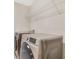 Convenient laundry room features modern washer and dryer units with space-saving overhead shelving for organized storage at 8042 Glenlloyd Ave, Winter Garden, FL 34787
