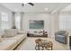 Comfortable living room featuring a plush sofa, contemporary decor, and a large screen TV at 8042 Glenlloyd Ave, Winter Garden, FL 34787