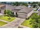 An aerial view of a single-story home showcasing landscaping, a two-car garage, and a well-manicured lawn at 810 Jefferson Blvd, Haines City, FL 33844