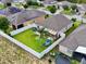 Spacious backyard featuring a lush lawn, a white vinyl fence, play set, and a covered patio at 810 Jefferson Blvd, Haines City, FL 33844