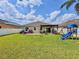 Spacious backyard featuring lush green grass, playground equipment, and a pergola covered patio at 810 Jefferson Blvd, Haines City, FL 33844