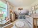 Charming Bedroom featuring a forest-themed wall, wooden crib, and natural light from the window at 810 Jefferson Blvd, Haines City, FL 33844