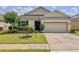 Charming single-story home with a well-manicured lawn, beautiful landscaping, and a two-car garage at 810 Jefferson Blvd, Haines City, FL 33844