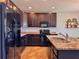 Well-equipped kitchen featuring granite counters, dark wood cabinetry, and sleek black appliances for modern living at 810 Jefferson Blvd, Haines City, FL 33844
