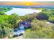 Beautiful aerial view of lakefront property with lush landscaping, private dock and sunset views at 822 S Breen Rd, Lake Wales, FL 33898