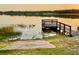 Peaceful lake view with a weathered wooden dock, reflecting the serene beauty of the natural surroundings at 822 S Breen Rd, Lake Wales, FL 33898