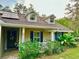 Charming home featuring solar panels, dormer windows, a cozy front porch with flourishing hibiscus at 822 S Breen Rd, Lake Wales, FL 33898