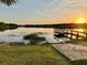 Picturesque sunset view over the tranquil lake, complemented by a private dock and lush green landscape at 822 S Breen Rd, Lake Wales, FL 33898