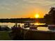 Sunset view of the lake from above-ground pool with deck and nearby boat dock at 822 S Breen Rd, Lake Wales, FL 33898